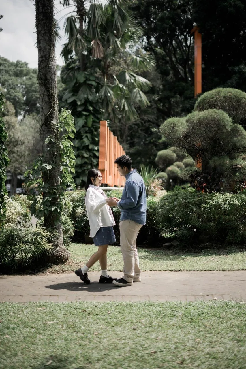 Bima dan Cilla berdiri berhadapan sambil berpegangan tangan di taman